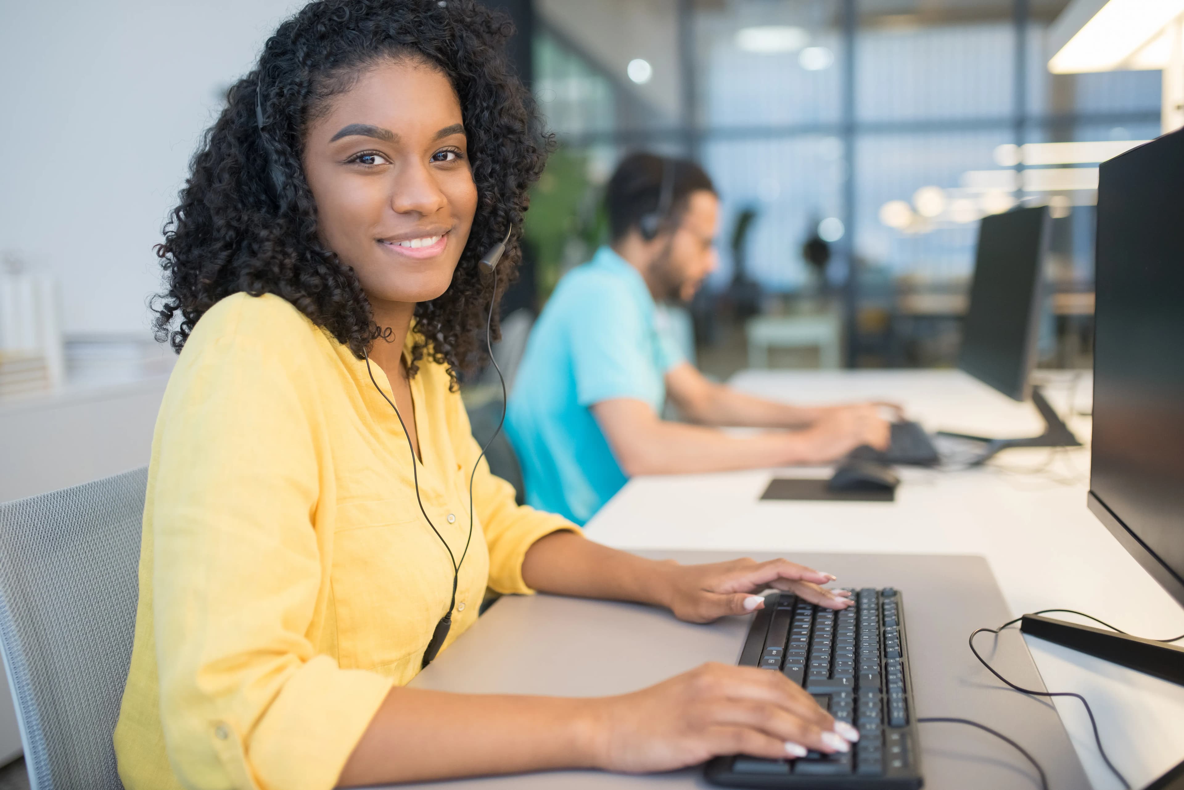 Office staff working at computers in a bright office