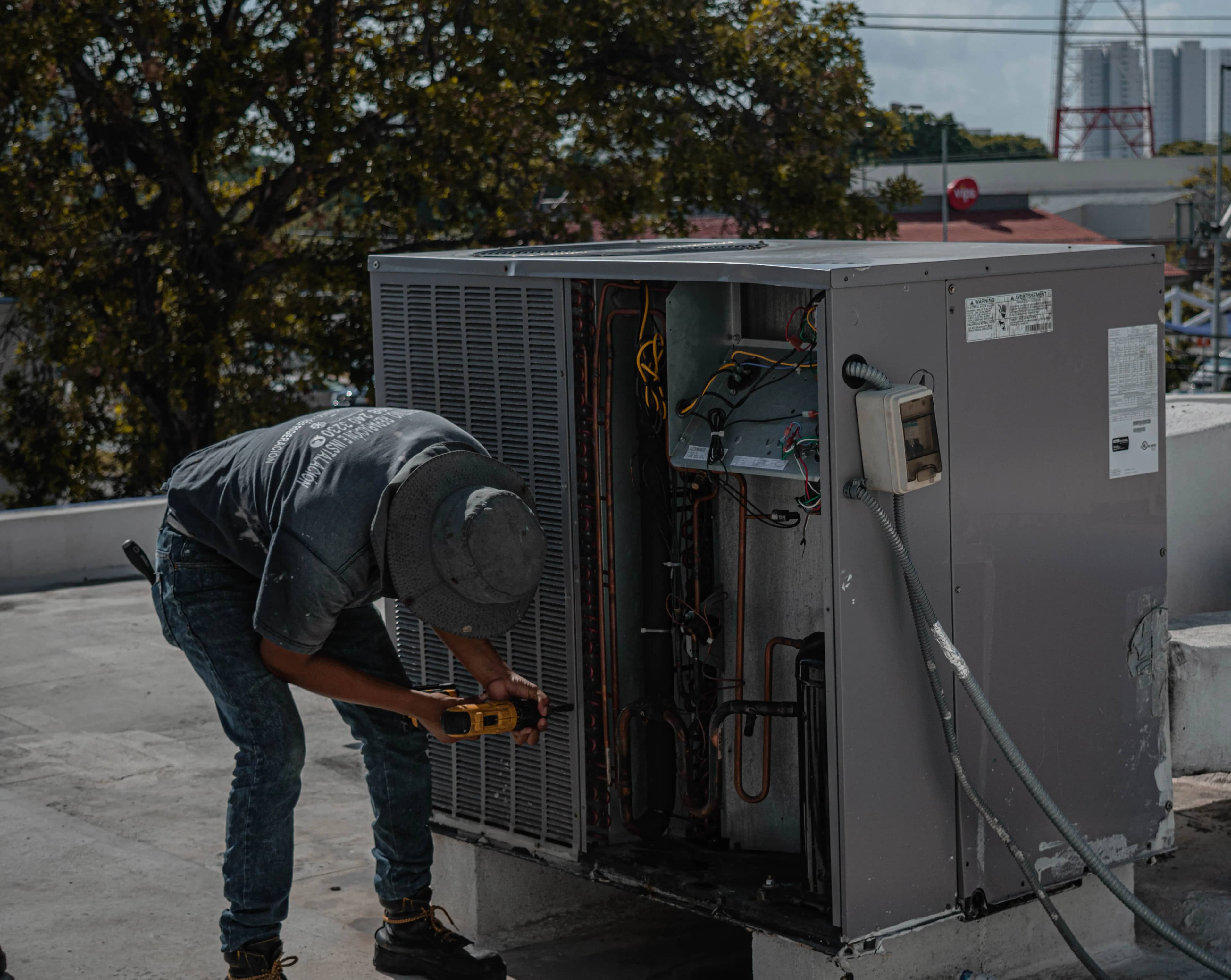 Technician servicing a rooftop air conditioning unit